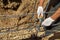 Workers hands using steel wire and pincers to secure rebar before concrete is poured over it