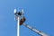 Workers install cellular base station with transmitters 3G, 4G, 5G and antennas on cell tower on background of blue sky. Mobile