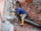 Workers installing underground utility and services pipe in the shallow trenches at the construction site.