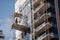 workers, installing windows on high-rise building, with scaffolding and glass in the background