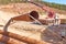 Workers are laying metal culverts under the highway under construction