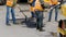 Workers laying stone mastic asphalt during street repairing works