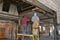 Workers on a lift removing ceiling boards on a renovation of an old warehouse.