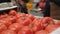 Workers on line of packing fresh tomatoes in trays inside factory.