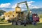 Workers load round hay bale from mown grass to a truck.  Tatras