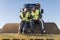 Workers looking phone in bulldozer shovel roll site