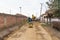 Workers with machinery preparing the road for new asphalt