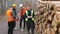 Workers measure timber sale trunk warehouse. Calculation products before loading