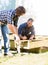 Workers Measuring Wood At Construction Site