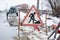 Workers in the municipal utilities repair a broken pipe in the winter. Excavated pit, fenced and with warning signs