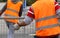 workers with orange high-visibility vest while moving the iron f