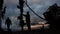 Workers in overalls and hard hats are carrying out repairs and maintenance of an oil well. Silhouette on the background