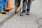 Workers perform minor repairs to pavement by spraying liquid asphalt into pits on roadway sealing cracks