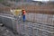 Workers pour concrete into the formwork of the wall