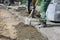 Workers prepare the surface for the installation of road curbs.