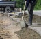 Workers prepare the surface for the installation of road curbs.