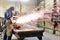 Workers in protective equipment in a foundry work on a casting with a grinding machine at the workplace