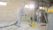 Workers in protective suits are grinding the concrete floor. Working process at a construction site. Construction