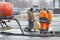 Workers pumped out the sewer near the road through the hatch with the help of two specialized cars