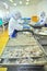 Workers are rearranging peeled shrimp onto a tray to put into the frozen machine in a seafood factory in the mekong delta of