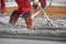 Workers in red boots with rake leveled the concrete