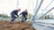 Workers in red helmets twist support with tool