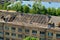 Workers repair and replace roofing on an old red brick building. Spring construction work. Repair and maintenance of city