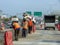 Workers repair roads during traffic.