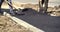 Workers on a road construction, industry and teamwork. Worker leveling fresh asphalt on a road construction site