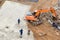 Workers smoothing concrete by trowel to finish concrete floor on construction site