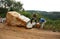 Workers split large rock for road-works