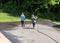 Workers spraying blacktop or asphalt sealer onto roadway