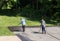 Workers spraying blacktop or asphalt sealer onto roadway