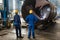 Workers supervising the manufacture of a metallic cylinder