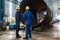 Workers supervising the manufacture of a metallic cylinder