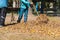 workers sweeping fallen leaves from a square in autumn