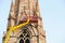 Workers on tall lifting platform repairing the church facade