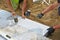 Workers tapping pavers into place with rubber mallets.