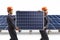 Workers in uniforms carrying a solar panel at a photovoltaic field