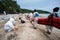 Workers and volunteers line up To put the plastic pallet in the sea near the beach In order to block crude oil.