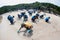 Workers and volunteers are shoveling sand with crude oil contaminated on the beach in a large plastic bag