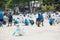 Workers and volunteers are shoveling sand with crude oil contaminated on the beach in a large plastic bag.