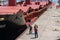 Workers walking beside large freighter
