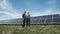 Workers walking in between rows of solar panels