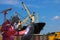 Workers welding process on metal steel pipe in shipyard.