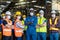 Workers and workers are standing in the factory. Group Staff Standing In Engineering Factory