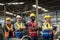 Workers and workers are standing in the factory. Group Staff Standing In Engineering Factory