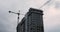 Workers working on the construction site. Construction of apartment building in green zone. Isolated residential complex under con