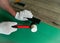 The workerâ€™s hands in white construction gloves hold a rubber mallet and a device for laying the laminate