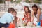 Working as a team on this one. a happy family building sandcastles together at the beach.